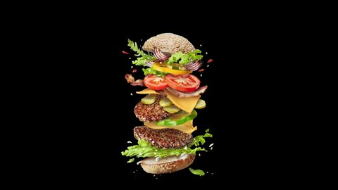 Movement of homemade delicious sandwich with flying ingredients beef cutlets, fresh organic vegetables and sesame bun on a black background. 4K UHD video 3840, 2160p.