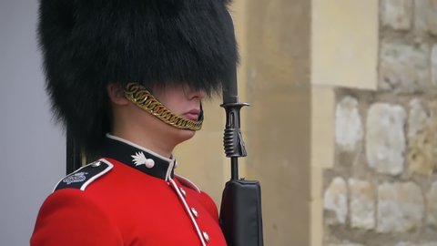 London, UK - April, 2019: Close-up portrait of a British Guard standing in the Tower of London. British guardsman examines the situation with a look. Armed British Queen's Guard, London, England.