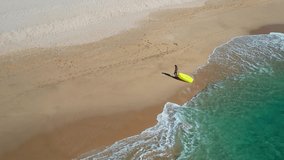 Young woman on the beach with air sofa. Pacific Ocean drone view. 4K 