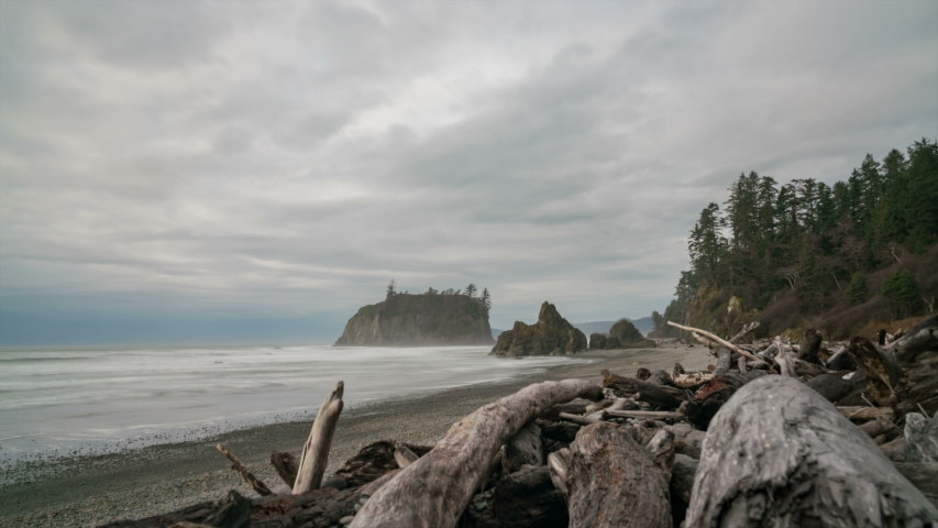 Timelapse of moody sky over driftwood at Ruby Beach in Pacific Northwest in Washington State