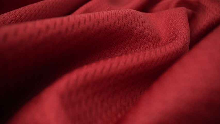 Close up detailed cloth texture of shiny spandex lycra cloth flowing with dolly shot in macro close-up view. Wavy clean elastic weave material. Textile abstract background. Clothing industry concept.