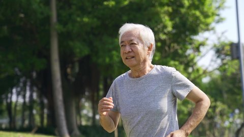 happy asian old man exercising jogging outdoors in park