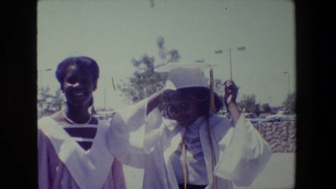 LANSING MICHIGAN -1983: Women Graduating Outside In A Cap And Gown With Her Friend