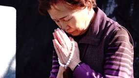 Asian elderly woman visiting a grave