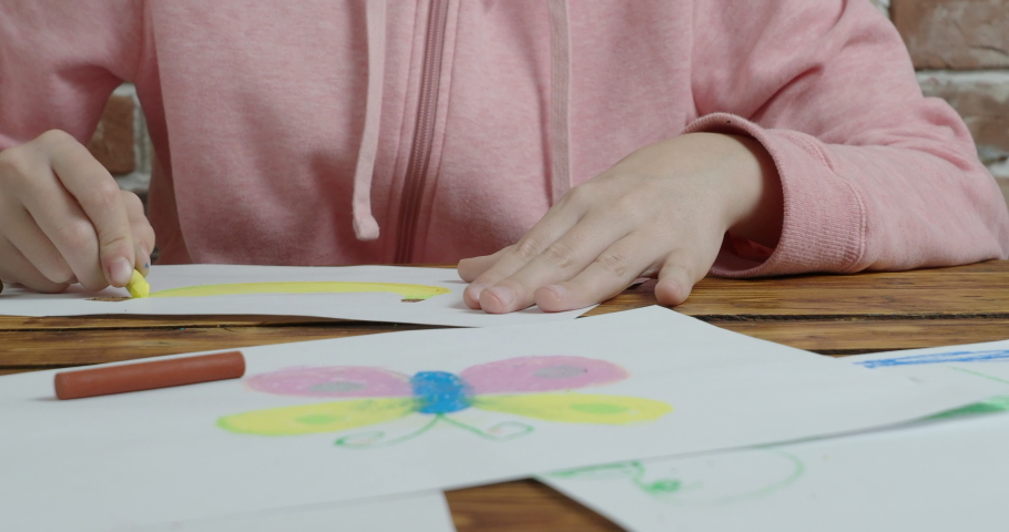 Boy and girl drawing by pastel on paper, close up video