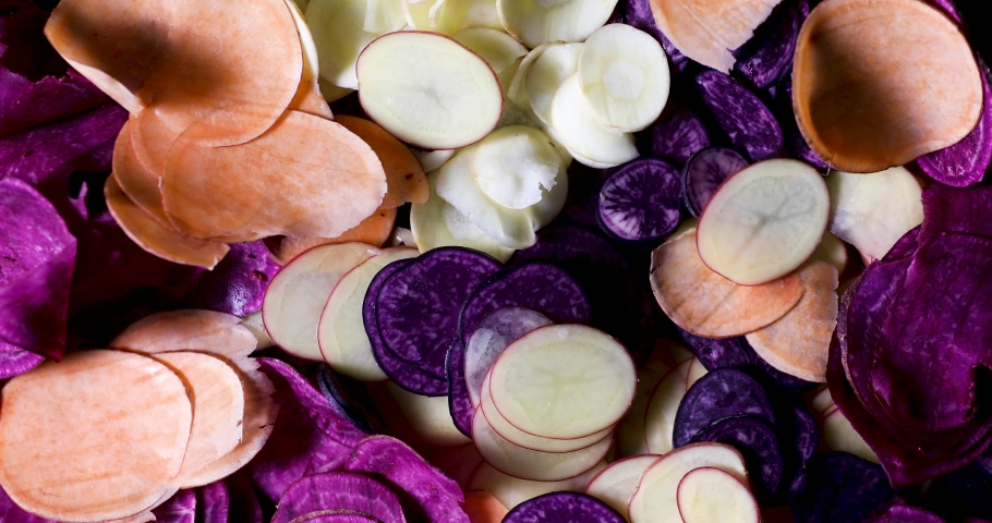 Slices of old potatoe types and parsnip for homemade chips