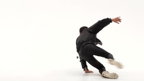 Little boy is dancing a modern dance on the white background in black leather jackets and jeans. Slow motion.