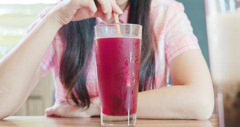 asian woman use reusable eco-friendly ecological bamboo straw to drink cranberry juice in restaurant without plastic waste garbage