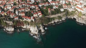 Aerial view with the city of Kavala in northern Greece, ancient aqueduct Kamares, old town, homes and medieval city wall, surrounded by turquoise sea