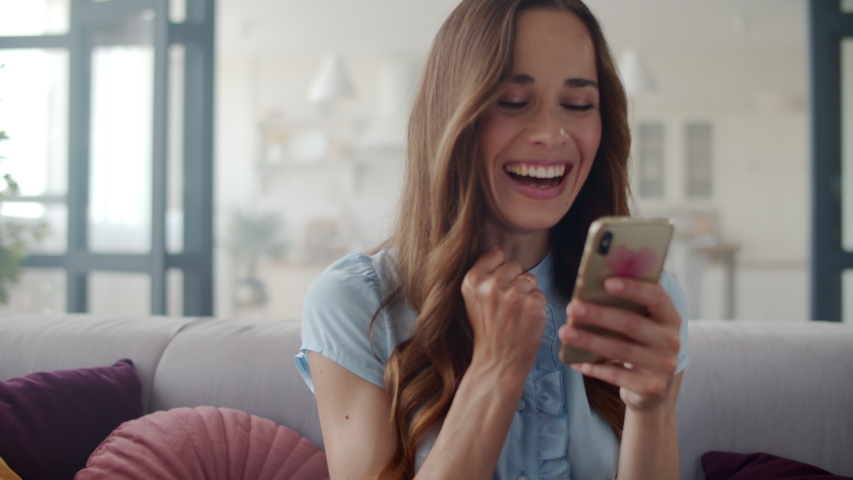 Portrait of happy business woman enjoy success on mobile phone at home office. Closeup joyful girl reading good news on phone in slow motion. Surprised lady celebrating victory on phone in apartment. | Shutterstock HD Video #1044575680