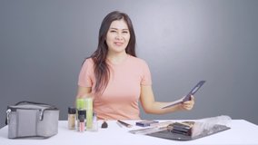 Beautiful female influencer talking about cosmetic products in the studio. Shot in 4k resolution