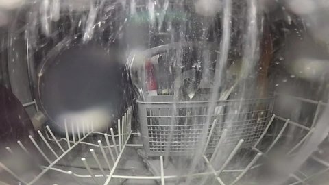The master repairs the dishwasher and checks the operation of the nozzle mechanism, which rotates and sprays water. The process inside the dishwasher. Inside view of a dishwasher.