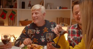 Head of families grandfather sits at table Christmas family smile gifts wine