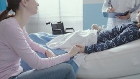 Professional friendly doctor visiting a young patient lying in bed at the hospital, her mother is sitting next to her and smiling, medicine and healthcare concept - Powered by Shutterstock - Get 15% off with code: PIKWIZARD15