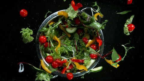 Super slow motion of rotating fresh mixed salad with water drops. Filmed on high speed cinema camera, 1000 fps.