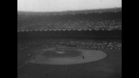 1940s: Baseball stadium. Crowd sits. Batter reaches home base. Men shake hands. Pitcher throws ball.