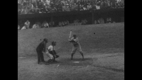1940s: Crowded baseball stadium. Player hits ball. Players run bases. Man slides into third base.