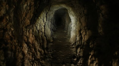 Flashlight or Torch on Walls of Abandoned Mine Tunnel.