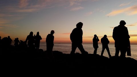Istanbul, Turkey - January 11, 2020 :  Silhouette of young people in sunset time, they are walking on rocks or taking photograph at Kadikoy Istanbul.