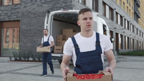 Transportation of Food on Truck or Order of Foodstuffs from Production Storage for Buy. Workers Carrying Boxes of Many Tomatoes Outdoors. Concept of Transfer Company or Carriage on Van in Slow Motion