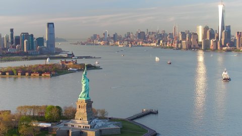 
Great aerial view of the Statue of Liberty at sunset. Manhattan and New Jersey skyline in the background. New York City, United States. Shot from a helicopter.