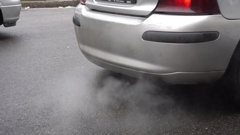 Italy , Milan January 15,2020 - detail of car exhaust fumes in the street congested car traffic and air pollution  - smog and 10 pm beyond the allowed limits - traffic block for polluting diesel car