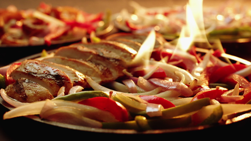 Chicken Fajita being plated on flaming  cast iron skillet Royalty-Free Stock Footage #1044661663