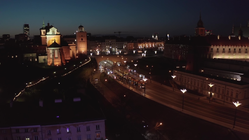 Aerial view of the old city of Warsaw.  Facade of the buildings is beautifully illuminated in the winter at night. Cityscape at dusk overlooking the royal palace and the square with a Christmas tree.