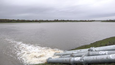 UK November 2019: Water is pumped out from the flooded village of Fishlake and back into the river Don through metal pipes at more than a ton a second.