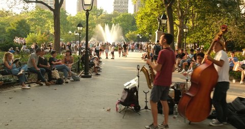 Manhattan, New York - September 19, 2019: People walk and relax by the fountain in Washington Square Park by the arch in summertime in Greenwich Village Manhattan New York City USA