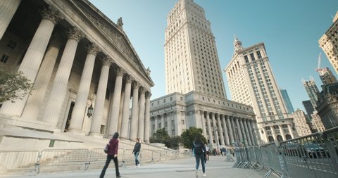 Manhattan, New York - September 19, 2019: People walk on the sidewalk outside the New York County Supreme Court and United States Courthouse buildings in downtown Lower Manhattan New York City USA