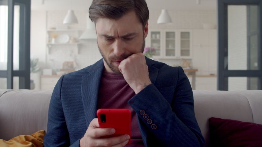 Closeup upset business man reading bad news on mobile phone at home office. Worried guy looking on phone in slow motion. Portrait of disappointed man feeling sad from negative news on couch. Royalty-Free Stock Footage #1044682654