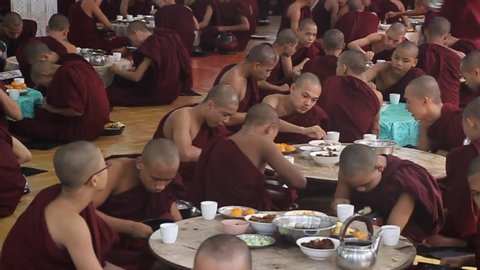 BAGO, MYANMAR - DECEMBER 10, 2016: Monks of Kya Kha Wain Kyaung temple in Bago eat their lunch.