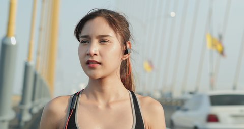 Young sporty woman using Wireless headphones for listen music when exercise วิดีโอสต็อก