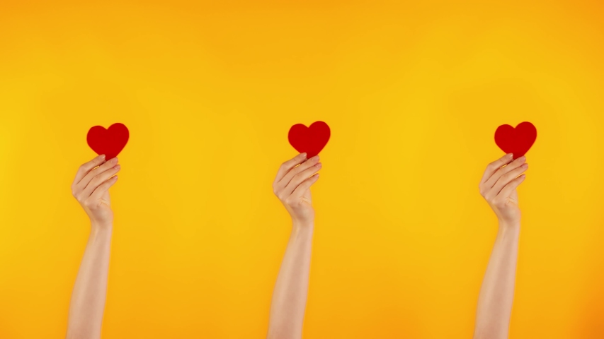Demonstration of love. Three female hands are holding red hearts. A blogger gets likes on social networks.  Royalty-Free Stock Footage #1044709120