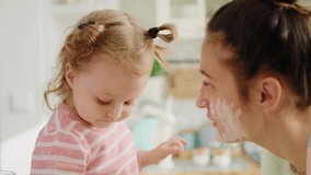 Handheld view of mum and little girl playing with flour. Shot with RED helium camera in 8K  