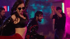 Footage of a crowd or group of young, stylish multi-ethnic people dancing in the rain . Colorful outdoor party at raining day . Dancers having fun dancing at party . Shot on ARRI ALEXA in Slow Motion