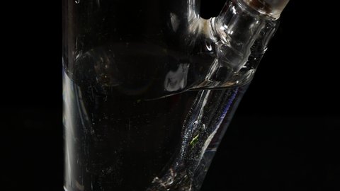 Glass Bong on black background.Smoking closeup.Marijuana,tobacco and Shisha.The smoke is passed through water to cool and mild smoke.Boiling water in a glass transparent bulb.Legalization in the world