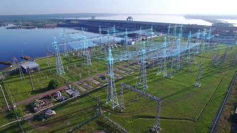 An aerial view a hydroelectric power station with infographic power flows motion graphics. Electric substation with tall pylons and hog voltage distribution cables. Early morning spring summer sun.