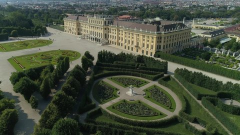 VIENNA AUSTRIA - JULY 10. 2019 aerial drone shot of Schonbrunn Palace / Schonbrunn Palace – camera tilting down from the palace garden side to the baroque garden looking straight down