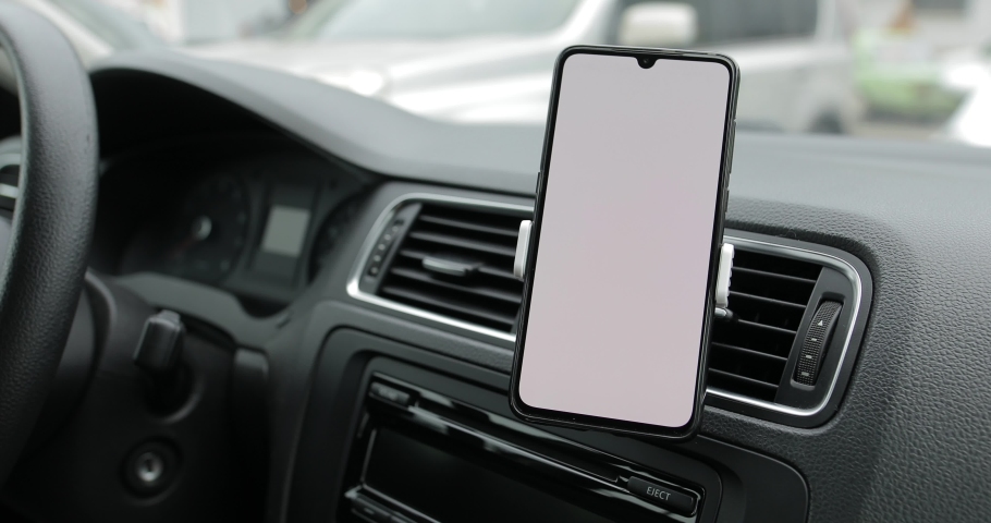 White empty screen of smartphone in a car, mockup for your site, view from passenger seat Royalty-Free Stock Footage #1044741967