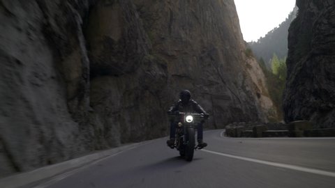 Bicaz Gorge, Romania - 11.07.2019: Crane rolling shot of a Harley Davidson motorcycle driving on a mountain road during autumn – Redaktionelles Stockvideo