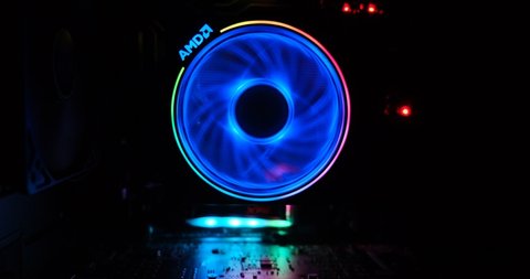 Athens, Greece - January 17, 2020: AMD Wraith Prism cooler with RGB lights spinning and changing colors, with lights reflected on a circuit board inside the computer case.