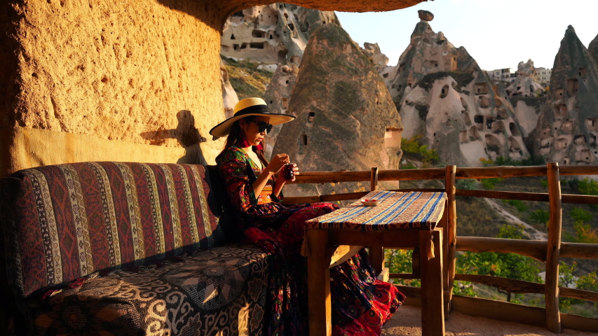 Woman drinking cay in traditional cave house in Cappadocia. traditional tea in Turkey.