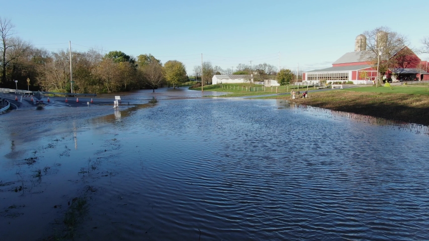 Farm family surveys flooded farm field, crop damage, road closed, in rural Lancaster County, Pennsylvania