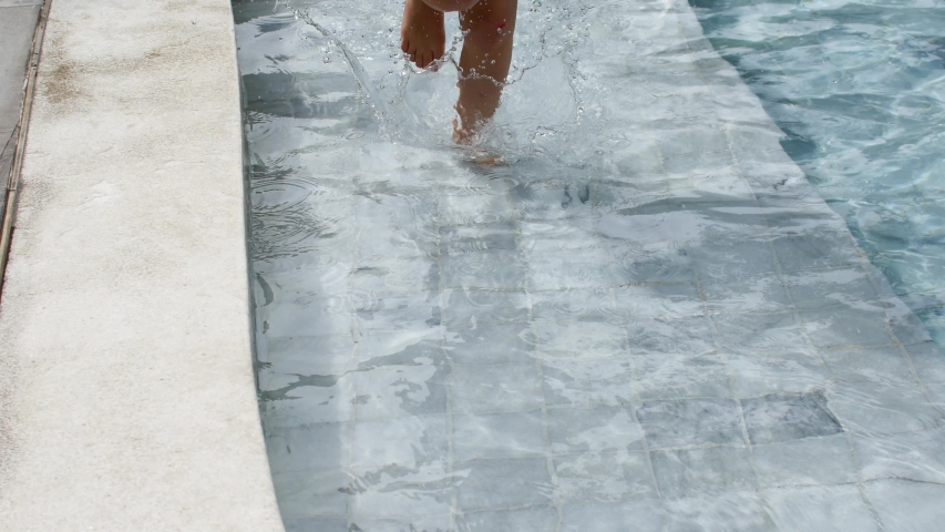 Child runs along the edge of the pool