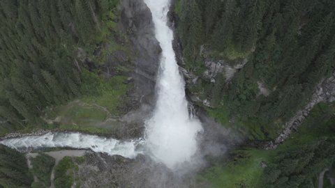 Aerial view of Krimml waterfall Cascades. Drone flight above strong water flow on rocks in spruce forest. Rainbow. Tirol, Salzburg land, Austria.