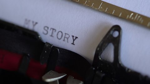 Typing words “my story” on a vintage typewriter. Close up, selective focus.