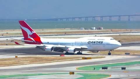 SAN FRANCISCO, CA - 2020: Qantas Boeing 747-400 Jumbo Jet Airliner Arriving in Heat Waves at San Francisco SFO International Airport Turning from Runway and Taxiing to the Terminal on Arrival