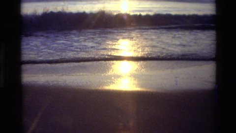 CARMEL CALIFORNIA USA-1982: Sunset Reflecting Off The Tide Of A Sandy Beach And Waves In The Sand